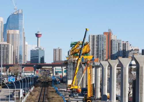 Construction occurring on the West LRT with downtown Calgary in the background.