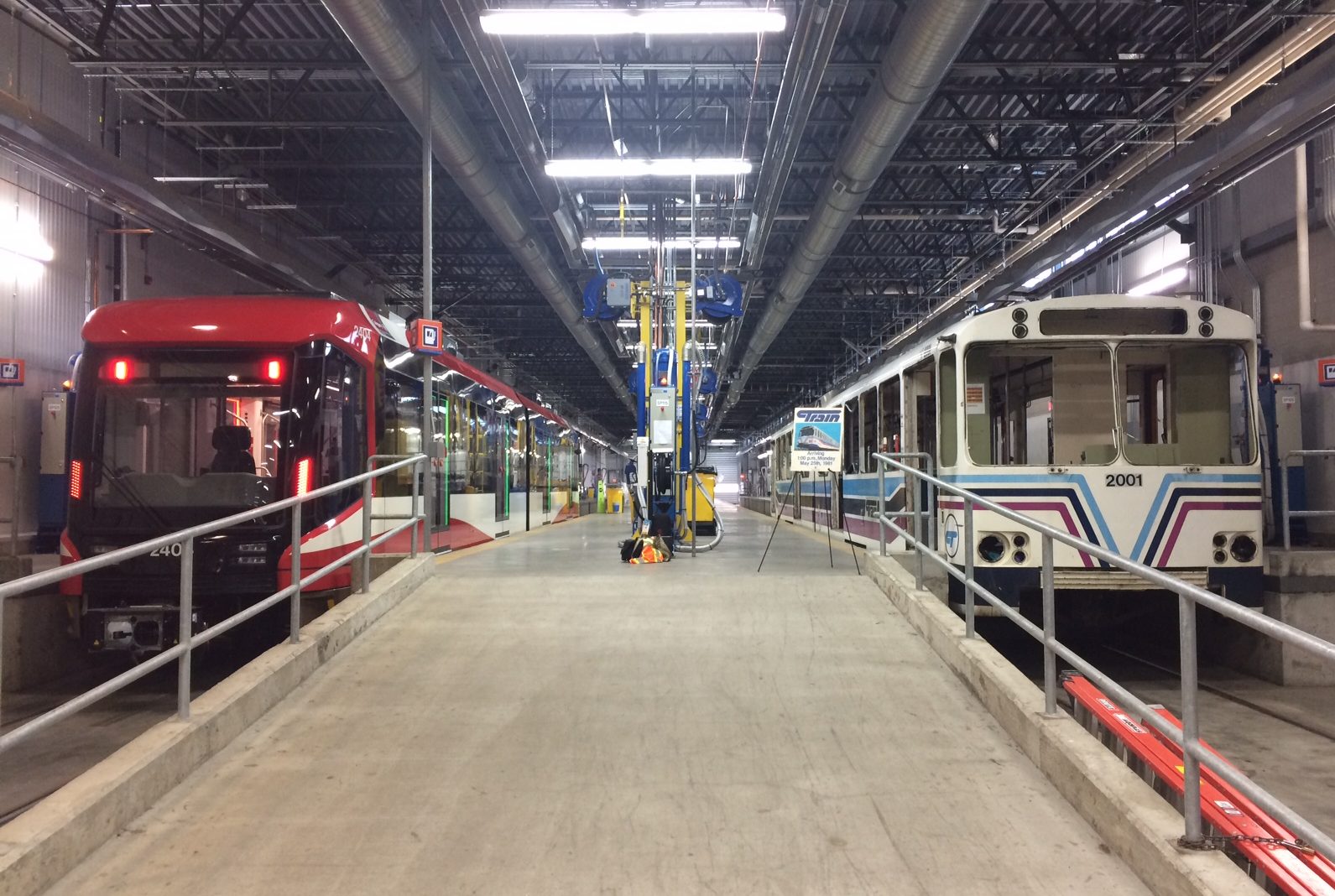 A new S200 LRV on the left with the first Car 2001 on the right, parked in the Maintenance and Storage Facility.