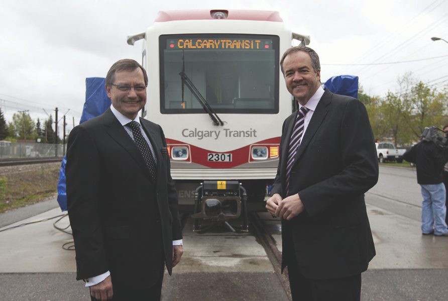 Premier Ed Stelmach (left) and Mayor Dave Bronconnier (right) stand  in front of the new Series 8 cars.