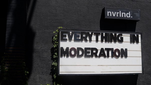 Sign in front of the nvrlnd art studio building - "Everything in Moderation".