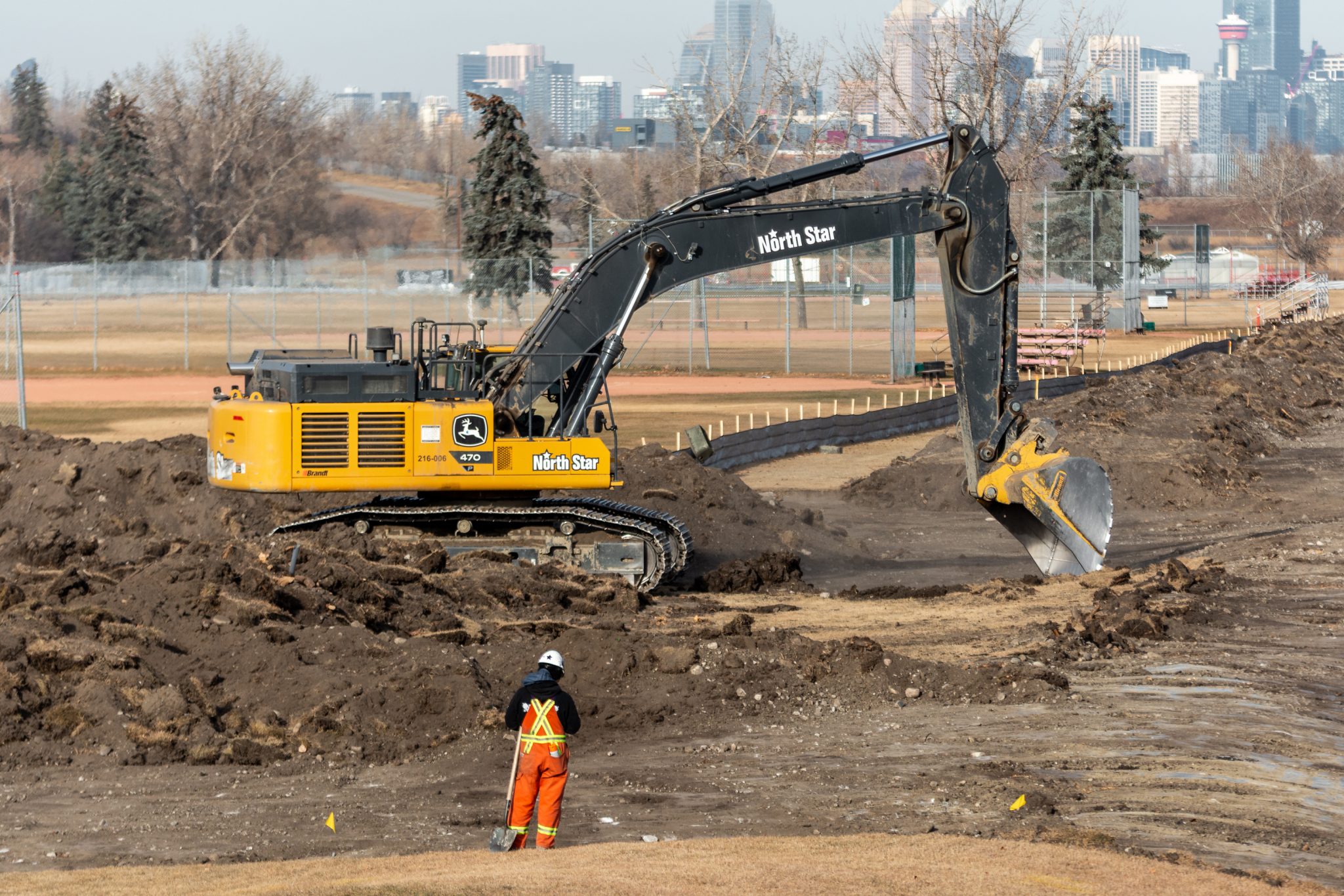 An excavator strips grass and topsoil at the Ogden Road Realignment project site in November 2025.