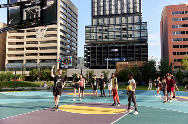 A man and woman sitting on yoga mats outside in the summer