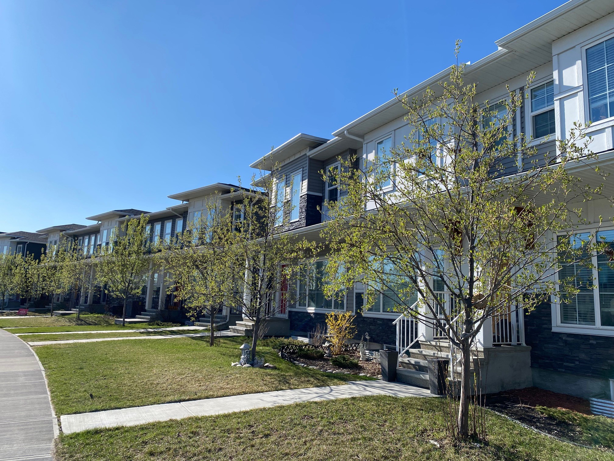 Rowhouses in Calgary with man and child walking