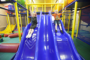 Kids going down an indoor slide